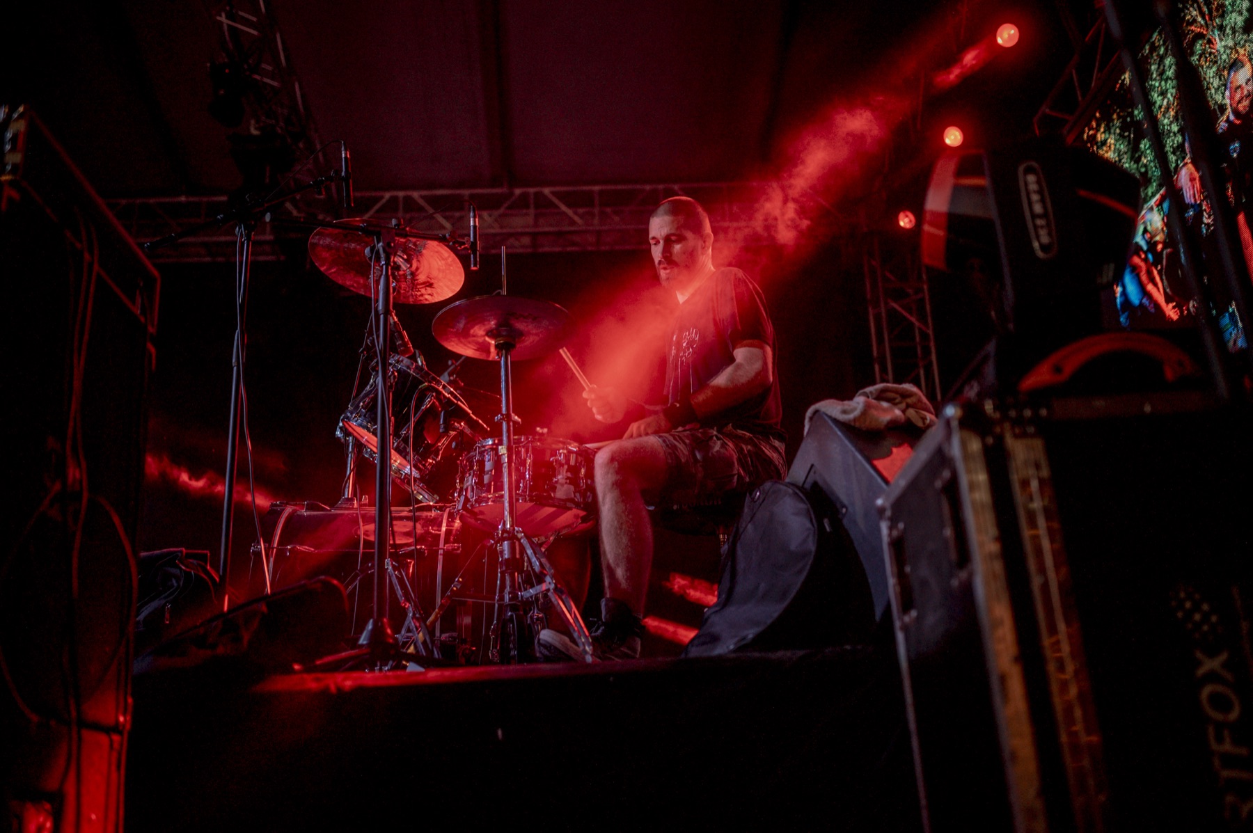 batteur en pleine action sur scène pendant un concert, cymbales et fûts visibles
