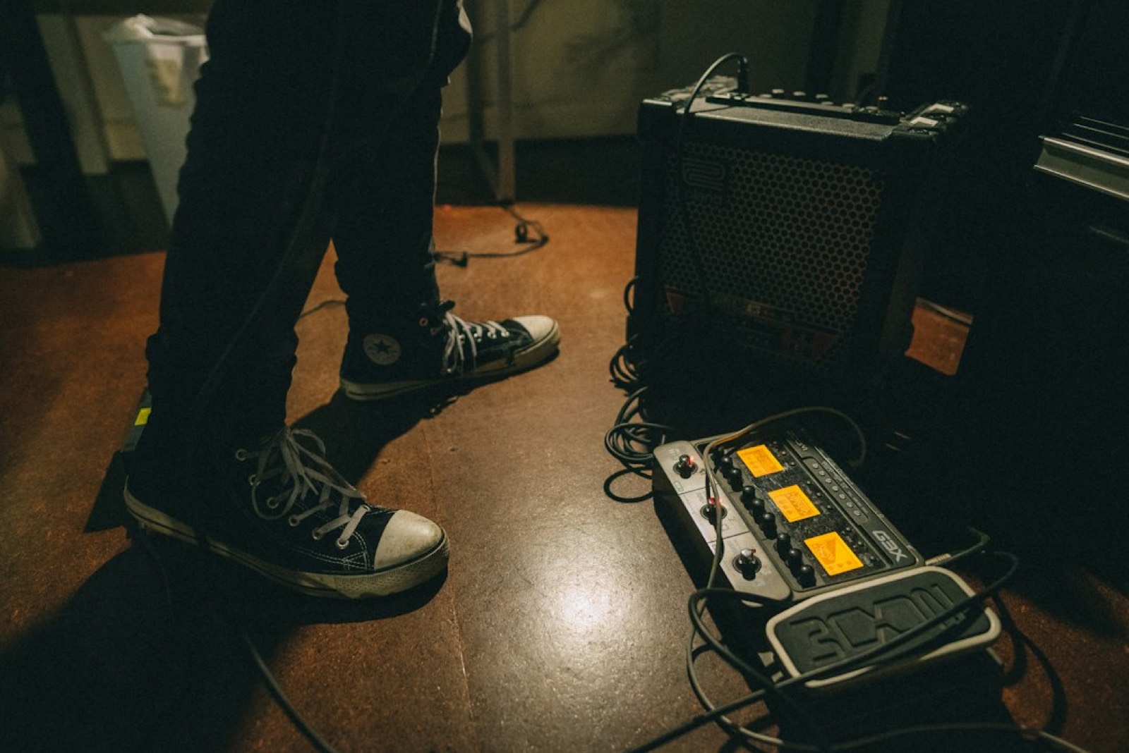 musicien réglant les boutons de son amplificateur avant une répétition