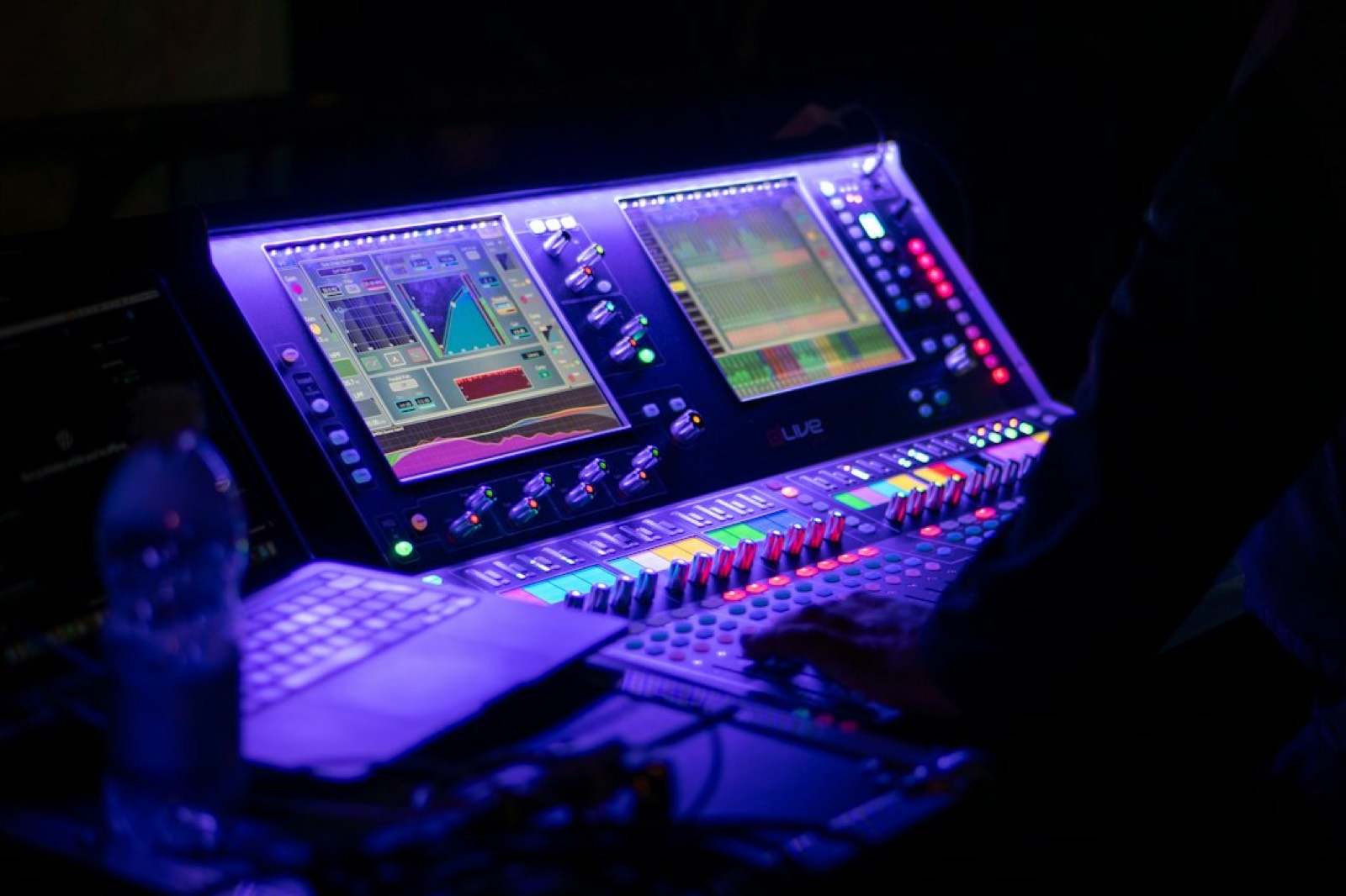 Ingénieur du son devant sa console de mixage pendant un concert