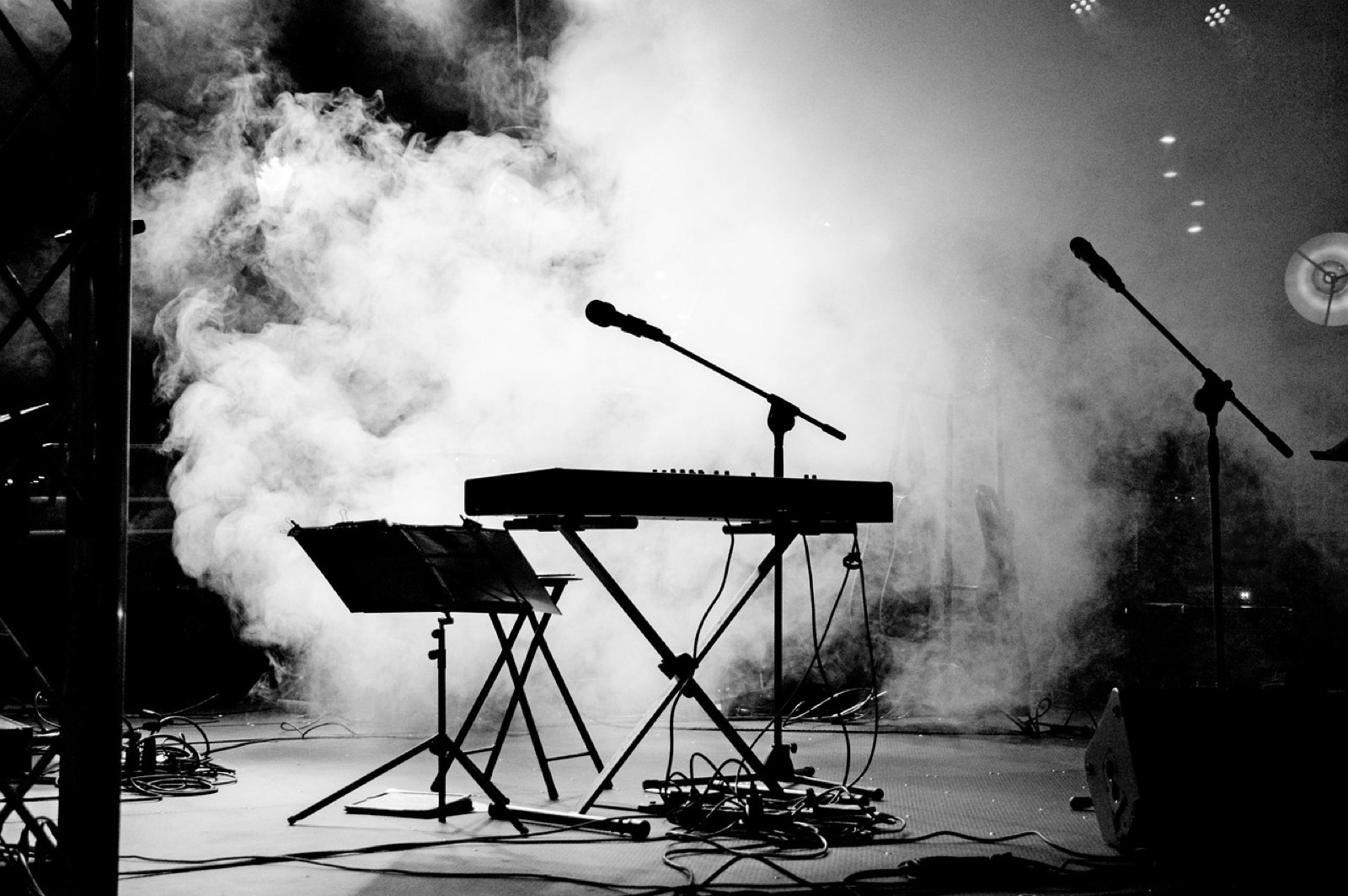 Enregistreur audio portable et microphone posés près d'une scène avant un concert