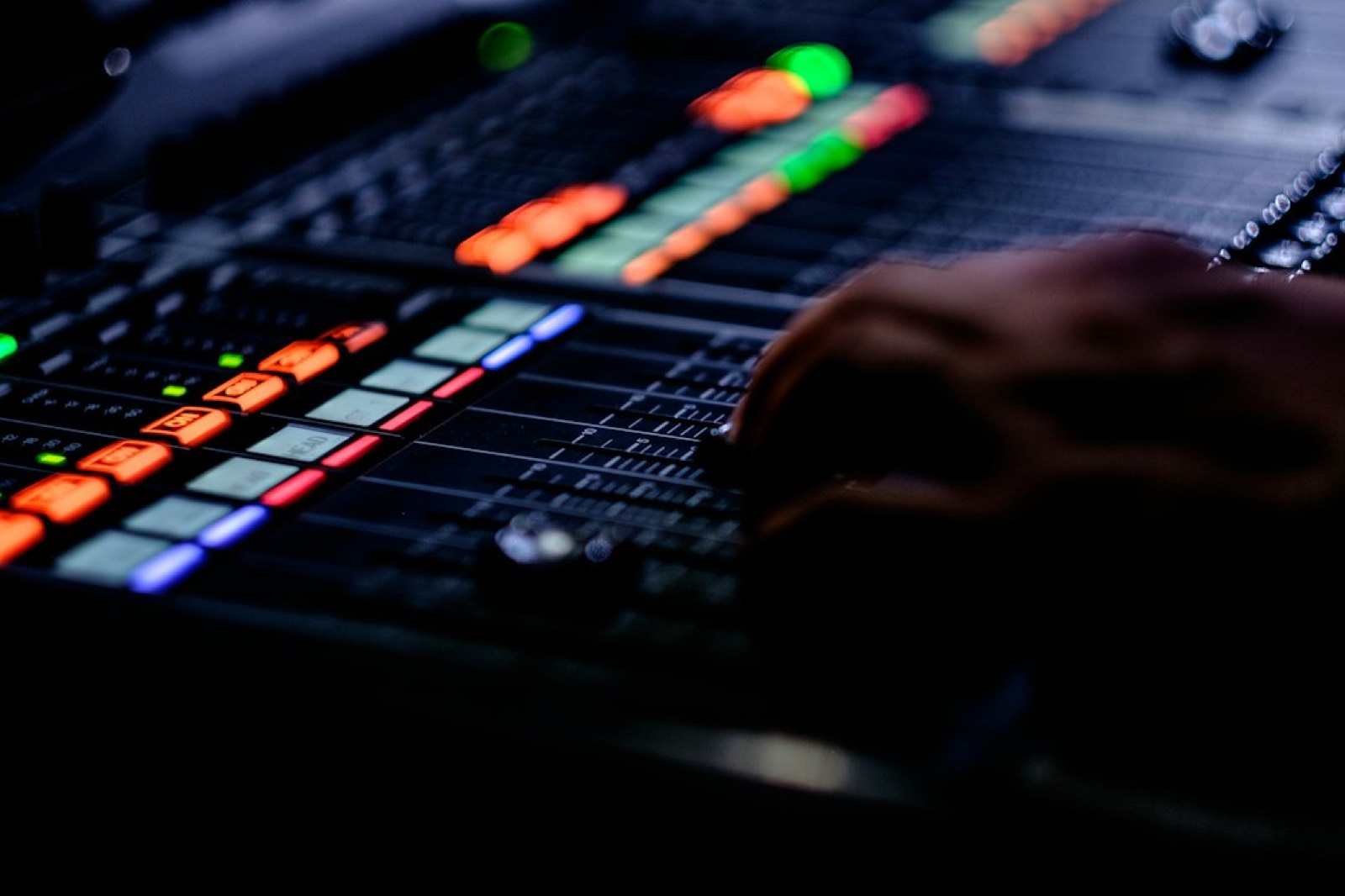 Main réglant les potentiomètres de gain d'une console de mixage